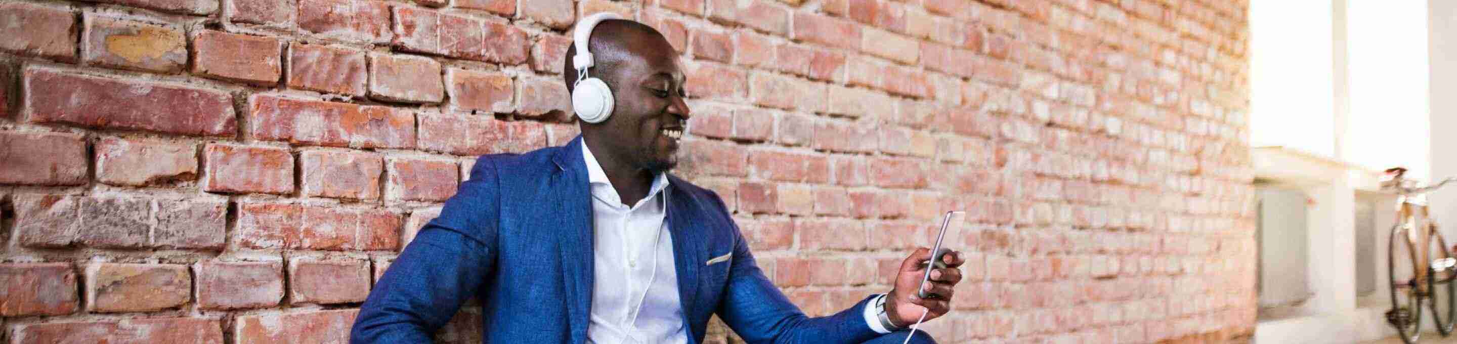 man in a blue suit listening to a podcast