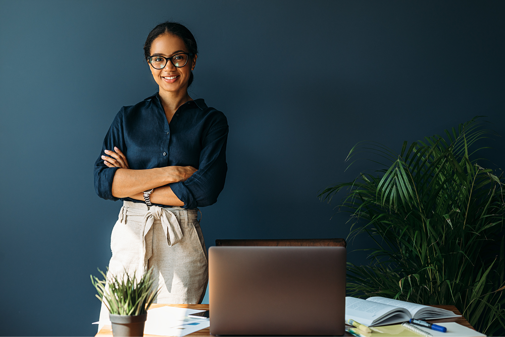 Portrayal of a Capella University online business student with a laptop and research materials.&nbsp;